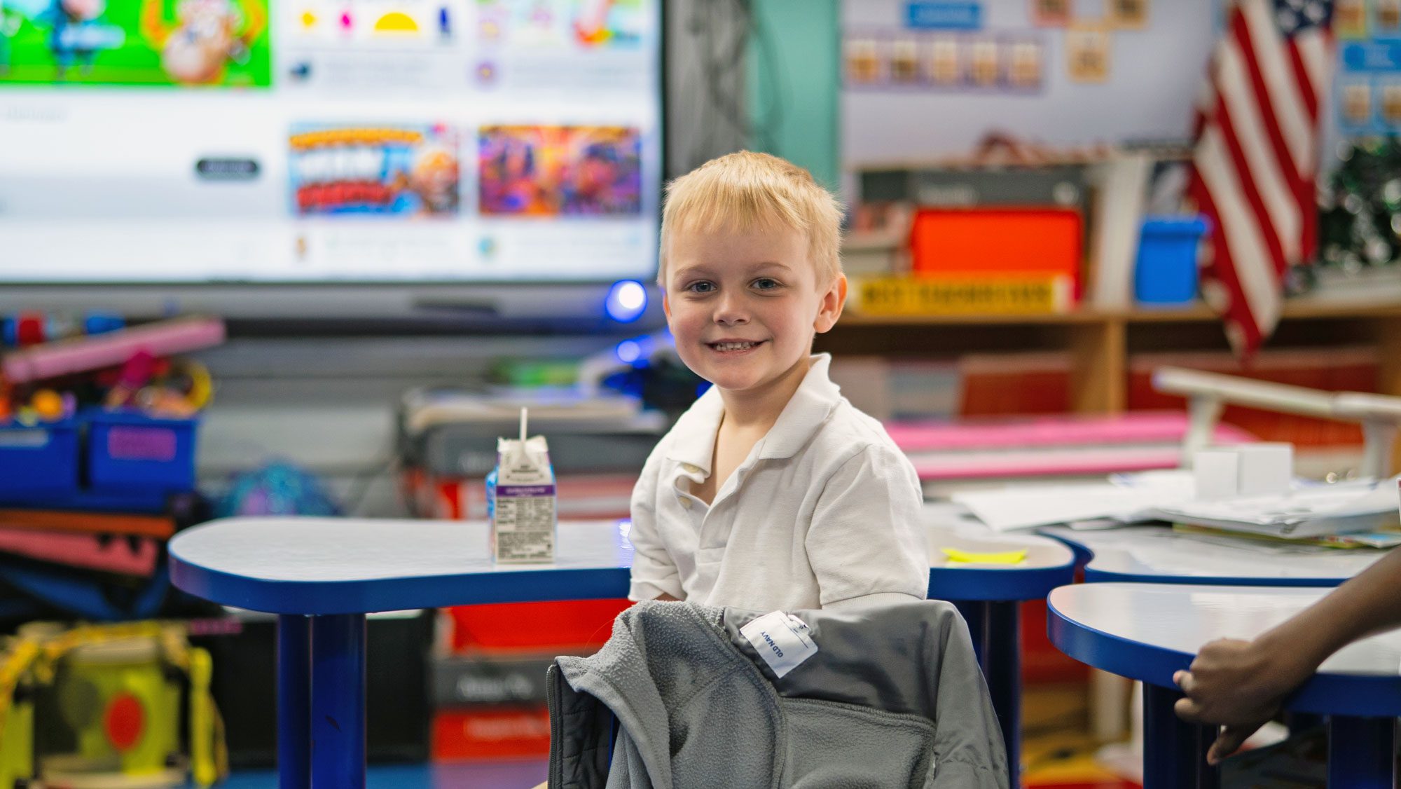 Elementary school student smiling at desk